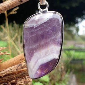 Pendentif améthyste chevronnée naturelle suspendue à une branche