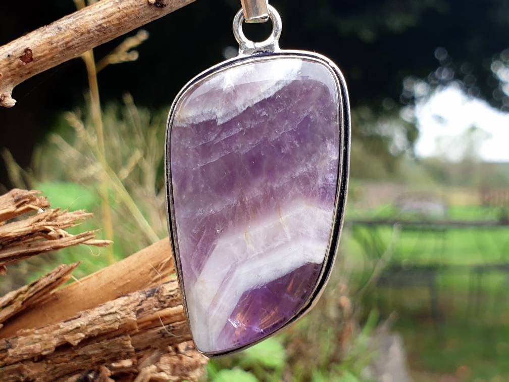 Pendentif améthyste chevronnée naturelle suspendue à une branche