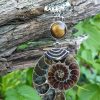ammonite fossilisée ou opalisée montée en pendentif avec un oeil de tigre
