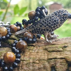 Corbeau en pendentif, sur collier de spinelle noir et oeil de tigre, collier de protection