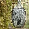 pendentif en pinolite suspendu à un arbre dans les bois, pierre naturelle noire et blanche