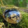 larme d'apache obsidienne dans une résine époxy avec feuille d'or, le tout monté sur chaine en acier inoxydable doré